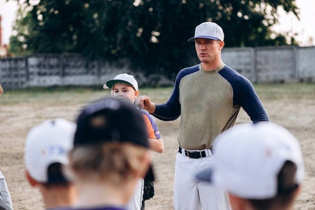 Il giovane allenatore di baseball istruisce i suoi studenti prima della partita