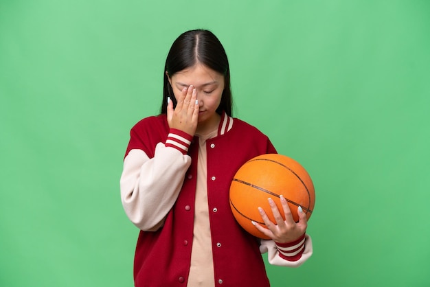 Young basketball player asian woman over isolated background with tired and sick expression