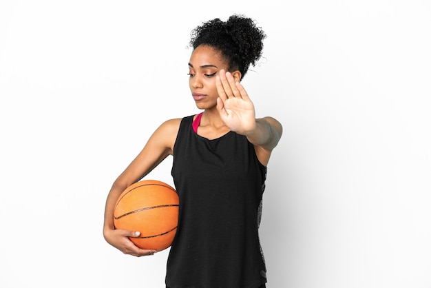 Young basketball player latin woman isolated on white background making stop gesture and disappointed