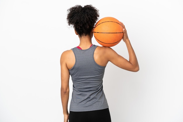 Young basketball player latin woman isolated on white background playing basketball in back position