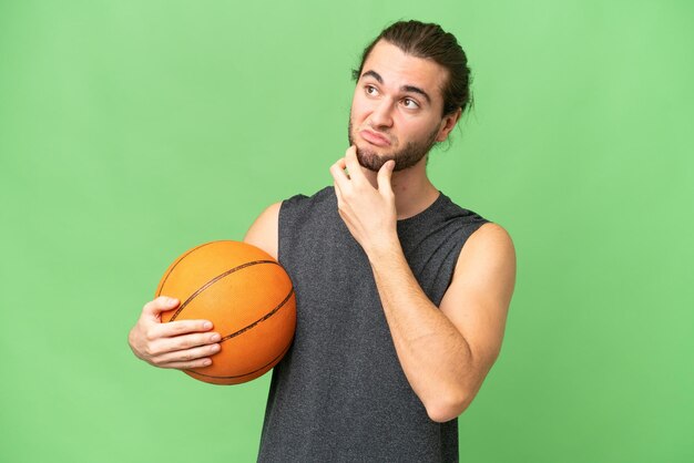 Young basketball player man over isolated background having doubts