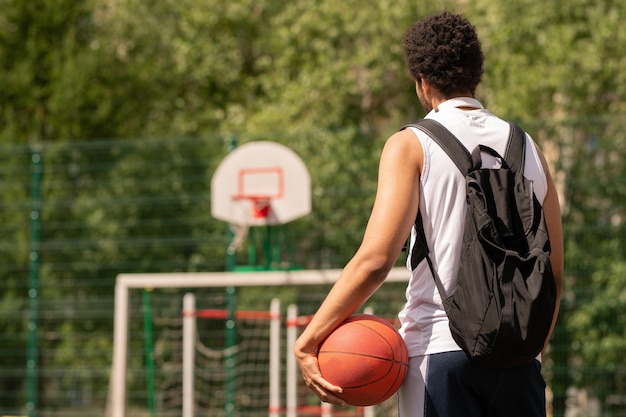 Photo young basketball player with ball ready for game standing on court or playground on sunny day