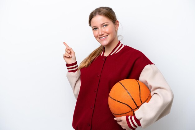 Young basketball player woman isolated on white background pointing finger to the side