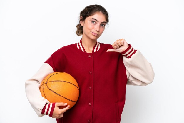 Photo young basketball player woman isolated on white background showing thumb down with negative expression