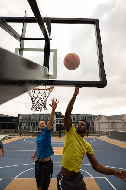 Молодые баскетболисты играют в баскетбол на баскетбольной площадке