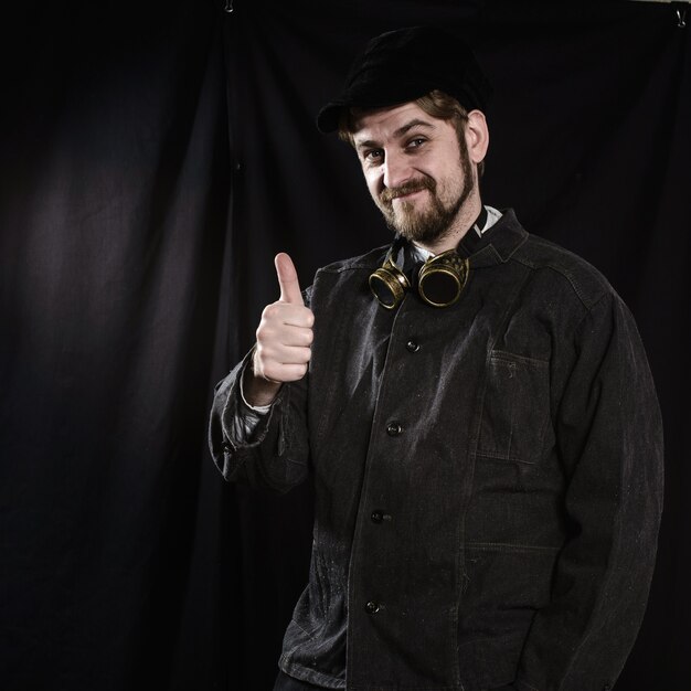 Young beard worker welder going thumb up