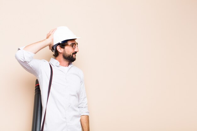 Young  bearded architect man confused or thinking