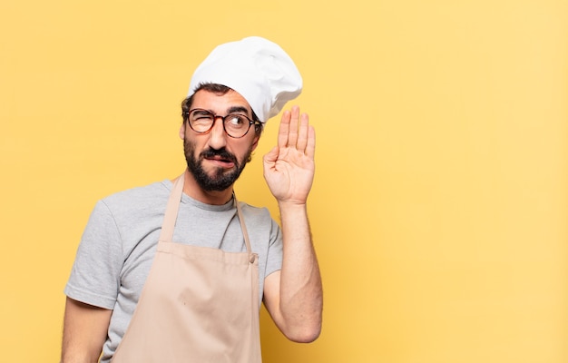 Young bearded chef man doubting or uncertain expression