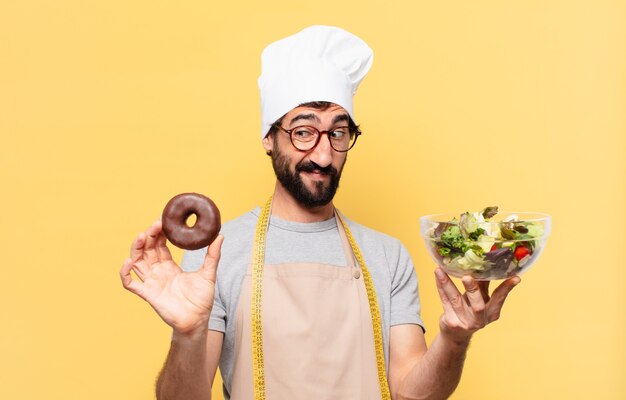 Young bearded chef man doubting or uncertain expression