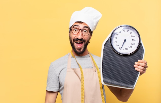 Young bearded chef man surprised expression and holding a scale