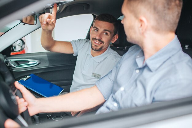 車に座っている若いとひげを生やしたコンサルタント