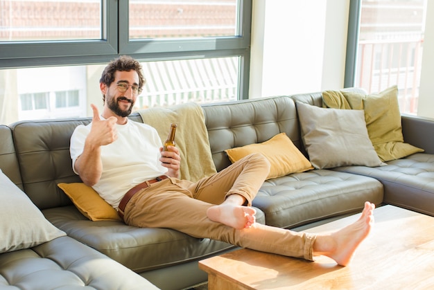 Young bearded cool man sitting on a couch at home