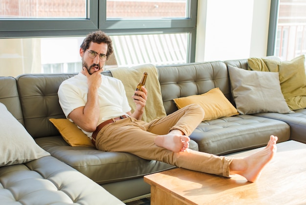 Photo young bearded cool man sitting on a couch at home