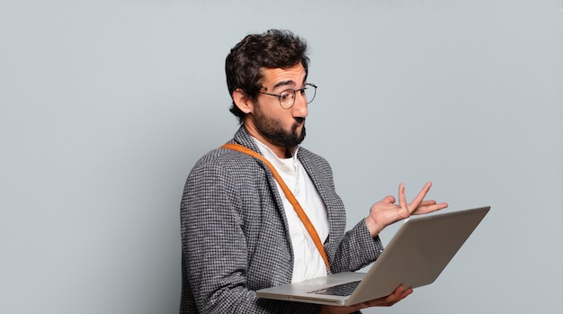 Young bearded and crazy businessman with a laptop