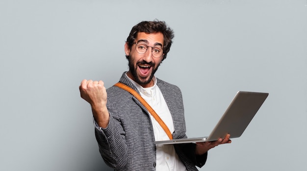 young bearded and crazy businessman with a laptop