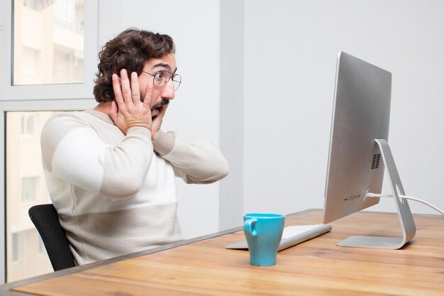 Young bearded crazy freelancer working with his computer