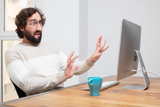 Young bearded crazy freelancer working with his computer