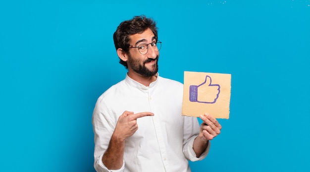 Young bearded crazy man holding a social media like sheet