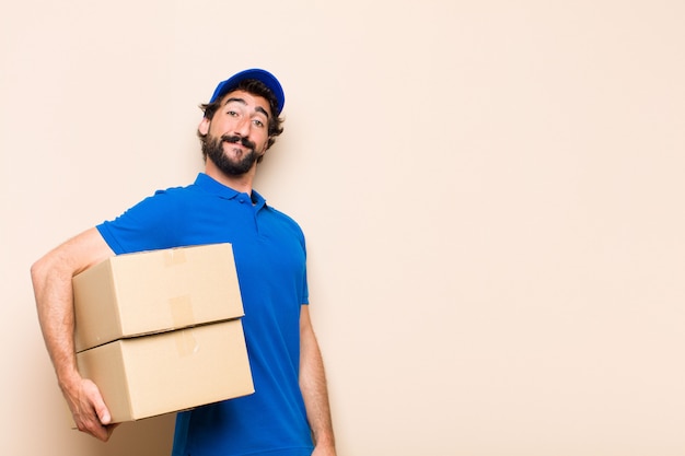 Young bearded delivery man with a box