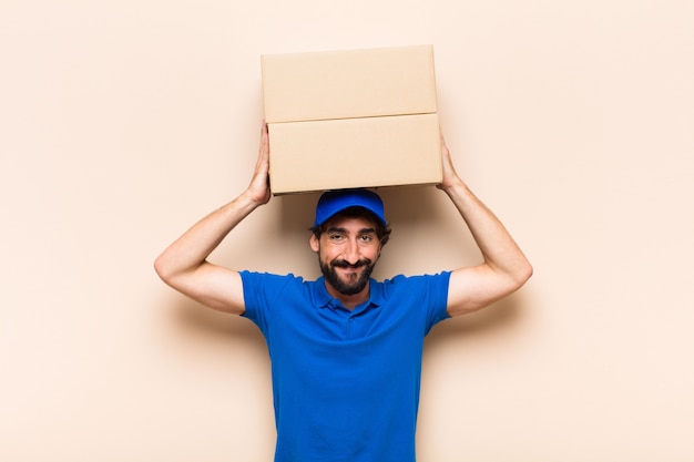 Young bearded delivery man with a box