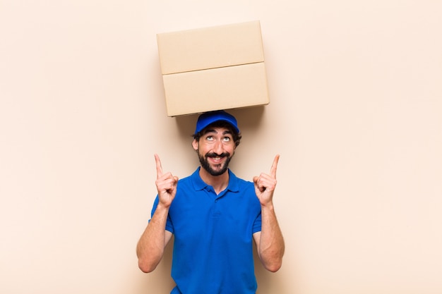 Young bearded delivery man with a box