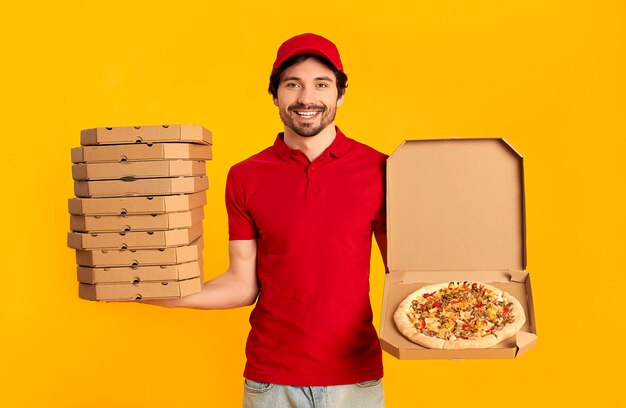 Young bearded delivery man with boxes of pizza isolated. home delivery