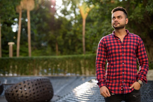 Young bearded Indian businessman relaxing at the mall in Bangkok