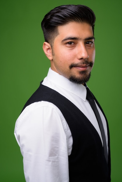Young bearded Iranian businessman on green