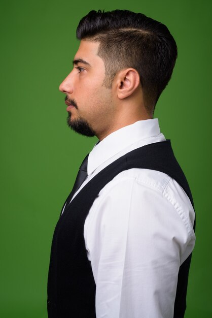 Young bearded Iranian businessman on green