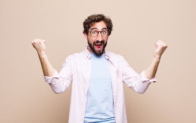 Young bearded man against flat wall