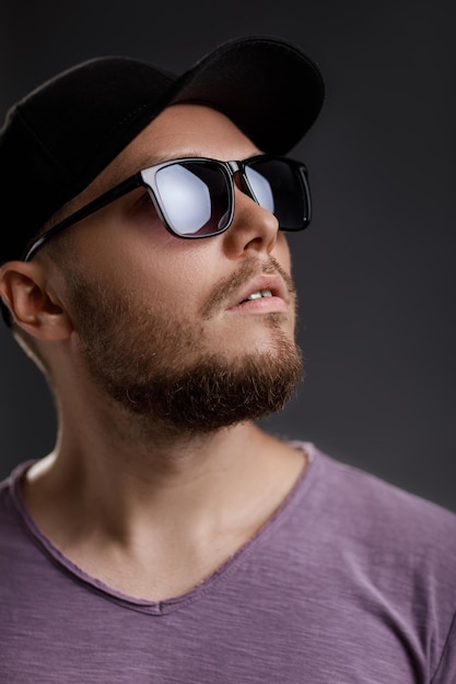 Young bearded man in cap and sunglasses