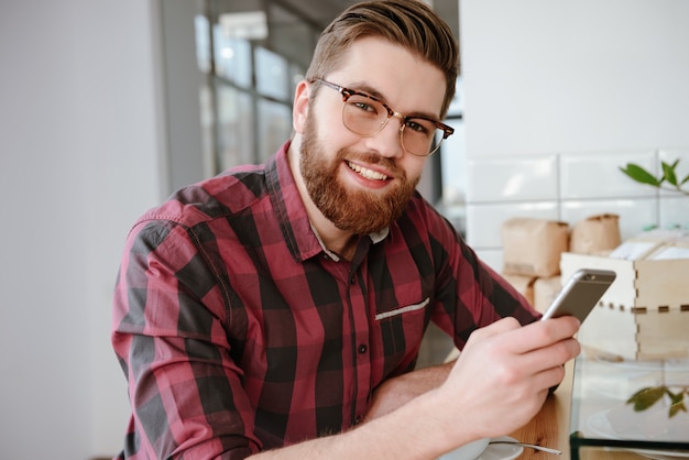 Young bearded man checking his newsfeed on social media