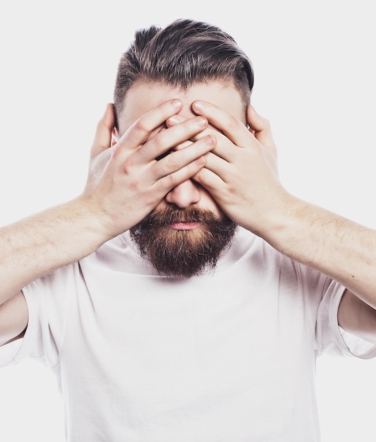 Young bearded man closing his eyes over white background