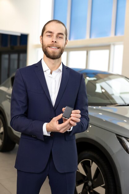 young bearded man in elegant suit with a car keys in hands