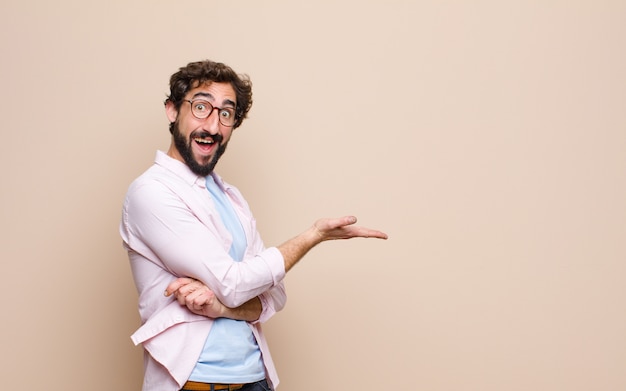 Young bearded man expressing a concept against flat wall