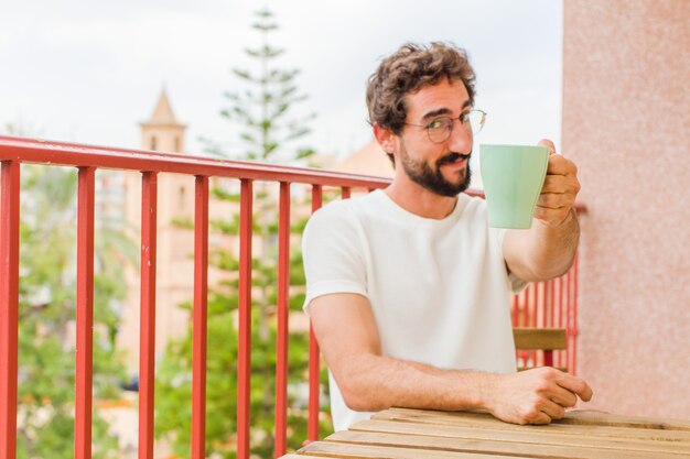 コーヒーを飲んでいる若いひげを生やした男