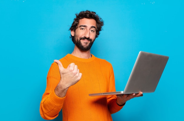 young bearded man holding a laptop. social media concept