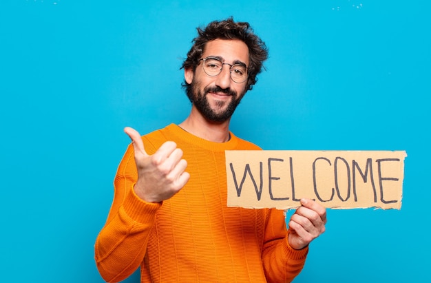 Young bearded man holding welcome board