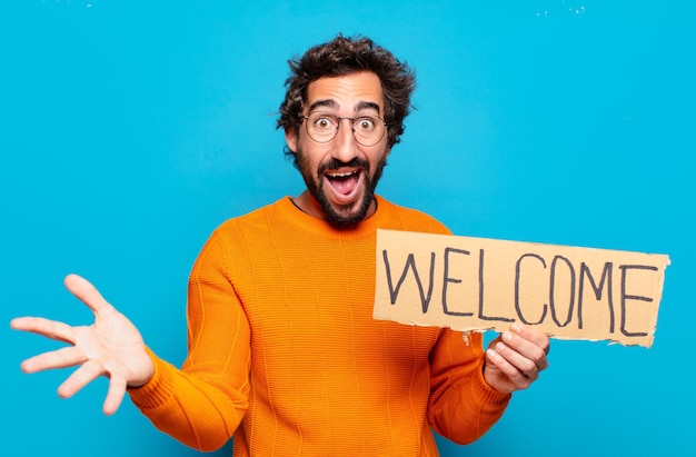 Young bearded man holding a welcome signboard