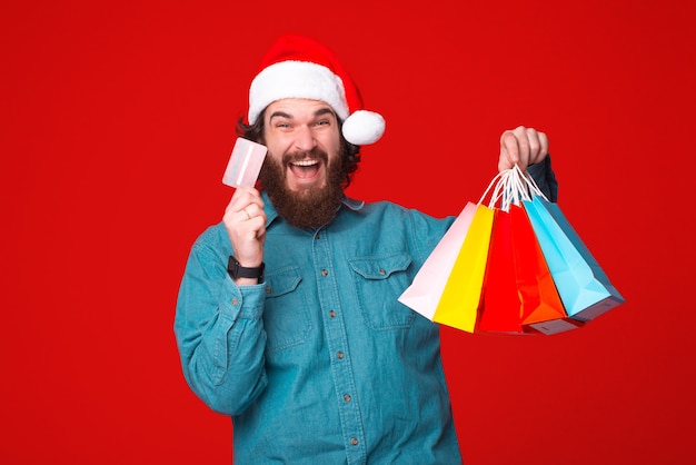 Young bearded man is excited about paying with credit card for his purchases.