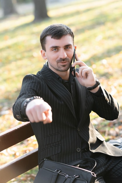 Foto un giovane uomo barbuto sta parlando al telefono e punta il dito verso la telecamera