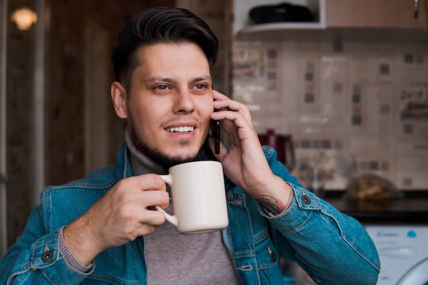 ジーンズのジャケットの若いひげを生やした男