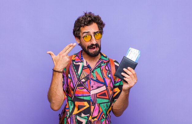 Young bearded man looking unhappy and stressed, suicide gesture making gun sign with hand, pointing to head