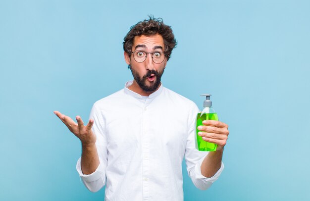 Young bearded man open-mouthed and amazed, shocked and astonished with an unbelievable surprise