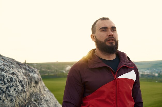 Young bearded man portrait outdoors in the mountains