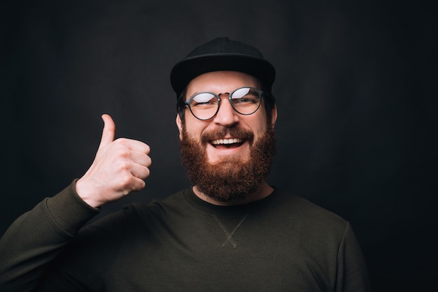 young bearded man showing thumb up or like gesture.