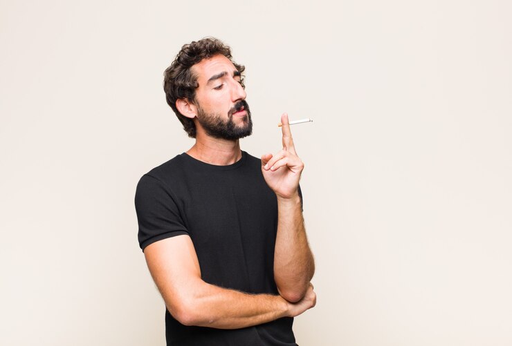 Photo young bearded man smoking a cigarette
