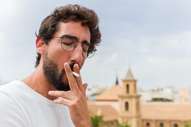 Young bearded man smoking a cigarette