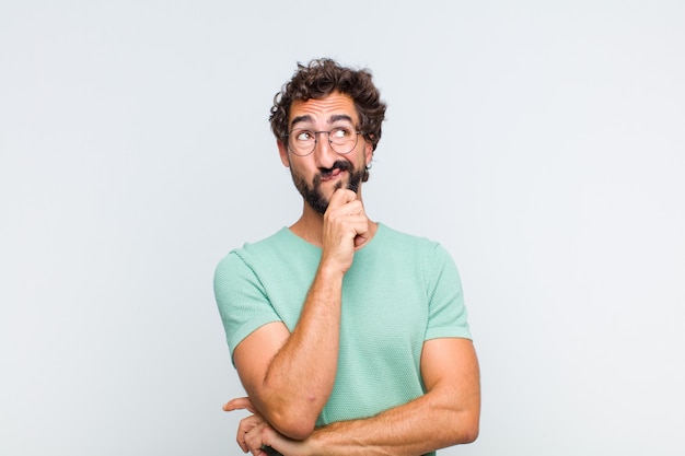 Young bearded man thinking, feeling doubtful and confused