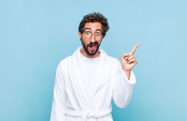 Young bearded man wearing a bath robe feeling like happy